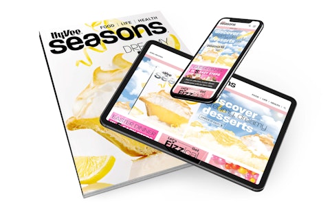 A tablet and mobile phone displaying content from Hy-Vee Seasons magazine on top of an issue of the magazine.